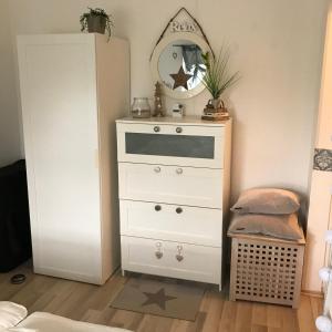 a white dresser with a mirror on top of it at Friesenhof in Friedrichskoog