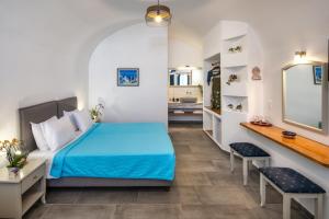 a bedroom with a blue bed and a mirror at Kalimera Hotel in Akrotiri +37 photos