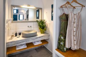 a bathroom with a sink and a mirror at Kalimera Hotel in Akrotiri