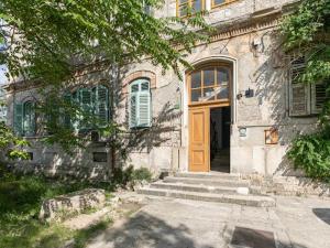 an old stone house with a wooden door and stairs at Polai Park Apartments in Pula