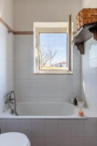 Casa Simone - Irpinia في Torella deʼ Lombardi: حمام أبيض مع حوض استحمام ونافذة