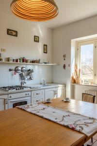 Casa Simone - Irpinia في Torella deʼ Lombardi: مطبخ مع طاولة خشبية ومطبخ مع دواليب بيضاء