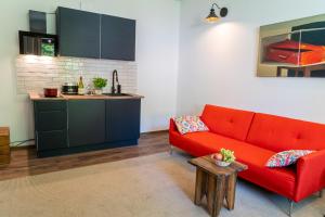 a living room with a red couch and a kitchen at Sokowirówka in Poniatowa