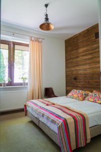 1 dormitorio con 1 cama con cabecero de madera y ventana en Sokowirówka, en Poniatowa