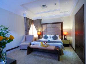 um quarto de hotel com uma cama e uma cadeira em Boudl Kuwait Al Fahahil em Kuwait