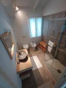 La salle de bains est pourvue d'un lavabo, de toilettes et d'un miroir. dans l'établissement IL NIDO, à Certaldo