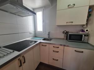 mała kuchnia ze zlewem i kuchenką mikrofalową w obiekcie Atico Barcelona IF Benidorm w mieście Benidorm