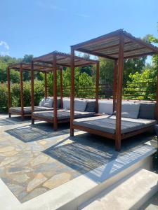 three beds under a gazebo on a patio at Sergios in Koukounaries