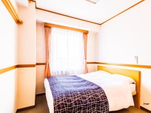 a bedroom with a bed and a window at APA Hotel Miyagi Furukawa-Ekimae in Osaki