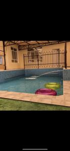 una piscina con tres frisbees en el agua en Sun shine chalet en Al Ḩadd