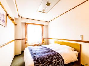 a bedroom with a bed and a window at APA Hotel Miyagi Furukawa-Ekimae in Osaki