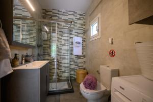 a bathroom with a shower and a toilet and a sink at Chic Apartment in Nature, 5-min walk to the Beach in Kalamata