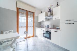 a kitchen with white appliances and a table and chairs at domo nora in Olbia