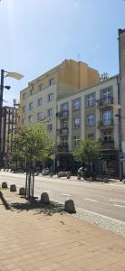 a building on a street with a tree in front of it at Mieszkanie 120m Gdynia Centrum ul Swietojanska in Gdynia