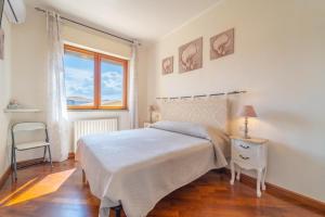 a white bedroom with a bed and a window at domo nora in Olbia