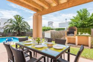 patio ze stołem, krzesłami i sprzętem do grillowania w obiekcie Villa Judith En Menorca w mieście Son Carrio