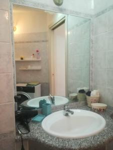 W łazience znajduje się umywalka i lustro. w obiekcie casa vacanze calasetta w mieście Calasetta
