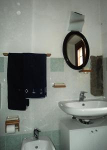 a bathroom with a sink and a mirror and a toilet at B&B Mirna in Vaprio dʼAdda