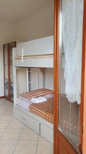 an empty bunk bed in a room with a glass door at Il Chicco apartment in Lamporecchio