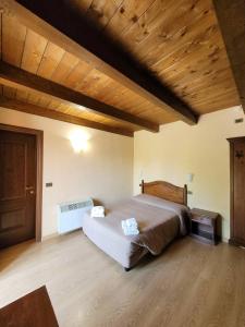 una camera con un grande letto e un soffitto in legno di Locanda San Pietro a Preturo