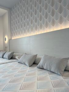 Un dormitorio con una cama grande con almohadas. en Hotel Sorra Daurada Splash, en Malgrat de Mar