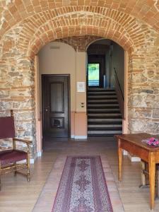 a hallway with a stone archway with a table and stairs at Locanda San Pietro in Preturo