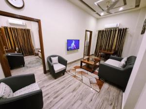 a living room with couches and chairs and a mirror at Hayyat Luxury Apartments in Lahore