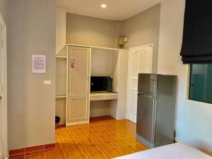 a kitchen with a stainless steel refrigerator and cabinets at Chernin hotel & Spa in Ban Bang Chak