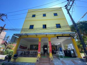 un edificio amarillo con una tienda delante en Chernin hotel & Spa, en Ban Bang Chak