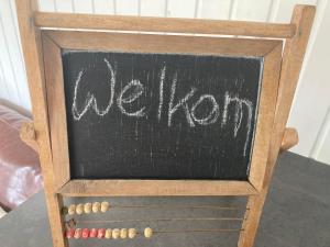 eine Tafel mit dem Wort Weisheit darauf in der Unterkunft Pipowagen Warm Welkom in Wezep