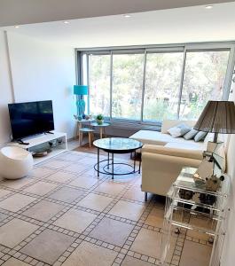 a living room with a couch and a table at SUPERBE APPARTEMENT DANS CADRE D'EXCEPTION - Piscine, Plage et Tennis privé in Bandol
