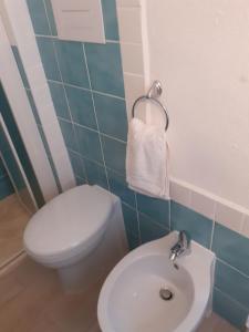 ein Badezimmer mit einem weißen WC und einem Waschbecken in der Unterkunft casa mariagrazia in La Caletta