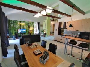 cocina y sala de estar con mesa de madera y sillas en The Forest House Krk 2, en Kras