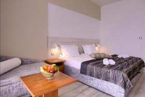 um quarto de hotel com uma cama e uma tigela de fruta numa mesa em Luna Beach Hotel - Half Board & All Inclusive em Golden Sands