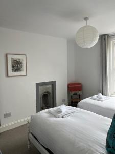 a bedroom with two beds and a fireplace at Luminous Town house by the sea in Kent +10 photos