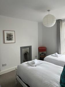 a bedroom with two beds and a fireplace at Luminous Town house by the sea in Kent