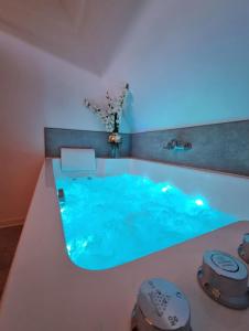 a swimming pool with a blue water in a room at Centre-ville le nid d'amour jacuzzi appartement in Rouen