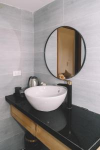 y baño con lavabo blanco y espejo. en Hang Mua Boutique Hotel, en Ninh Binh