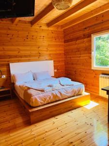 a bedroom with a bed in a log cabin at Bujtina Dini in Rubik