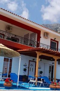 a house with blue chairs and a balcony at Ikaria Studios in Manganítis