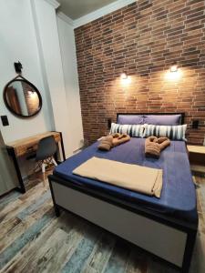 a bedroom with a large bed with a brick wall at Grecos STAY SKIATHOS in Skiathos Town