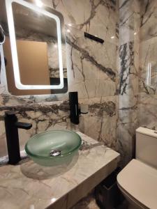 a bathroom with a green bowl sink on a marble counter at Grecos STAY SKIATHOS in Skiathos Town