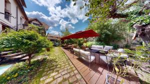 a patio with chairs and a red umbrella at Besharat Gallery & Museum in Barbizon