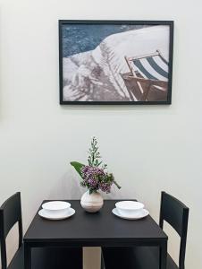 a black table with two chairs and a vase with flowers at 42 Zanardelli B&B in Trani