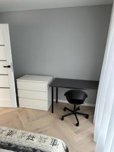 einen Schreibtisch und einen Stuhl in einem Zimmer mit einem Bett in der Unterkunft Birutės parko apartamentai in Palanga