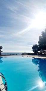a large pool of blue water next to a beach at SUPERBE APPARTEMENT DANS CADRE D'EXCEPTION - Piscine, Plage et Tennis privé in Bandol