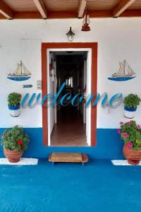 a sign on the side of a building with plants at Ikaria Studios in Manganítis