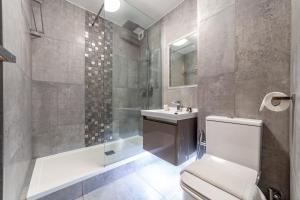 La salle de bains est pourvue de toilettes, d'un lavabo et d'une douche. dans l'établissement The Ealing Collection, à Londres