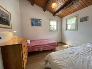 a bedroom with a bed and a dresser and two windows at Maison Noirmoutier-en-l'Île, 5 pièces, 8 personnes - FR-1-224B-477 in Noirmoutier-en-l'lle