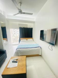 een kleine slaapkamer met een bed en een tafel bij Studio apartment nearby Dhaka airport in Dhaka